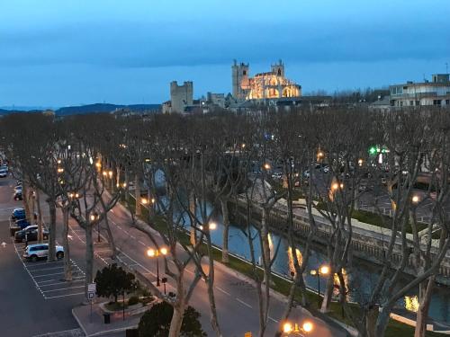 a city with street lights and a castle in the background at LE MONICA in Narbonne