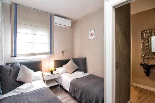 a hotel room with two beds and a window at tuGuest Darro Apartment in Granada