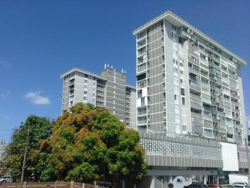 two tall buildings with a tree in front of them at Zen Retreat City Center Near Train in San Juan