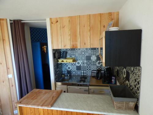 a small kitchen with wooden cabinets and a counter top at Les Marinas de Cassy in Lanton