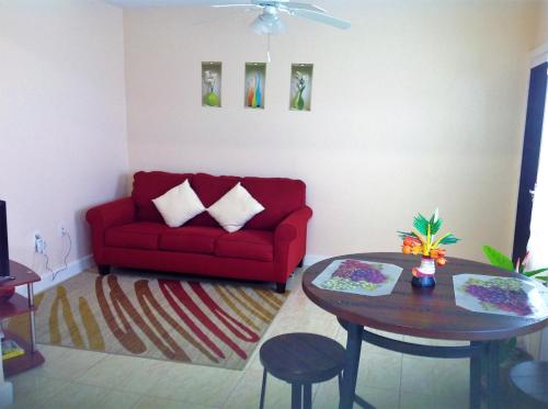 a living room with a red couch and a table at Beacon Rise Apartment in Basseterre