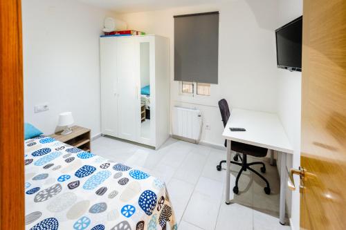Habitación pequeña con cama y escritorio. en Carrer Sevilla, en Tarragona