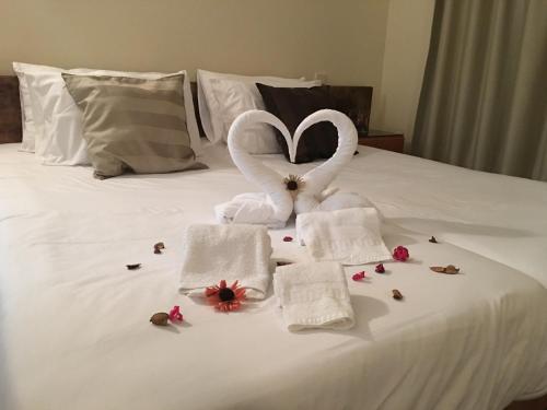 a bed with towels in the shape of a heart at Fiel Chef Alojamento Local in Valongo