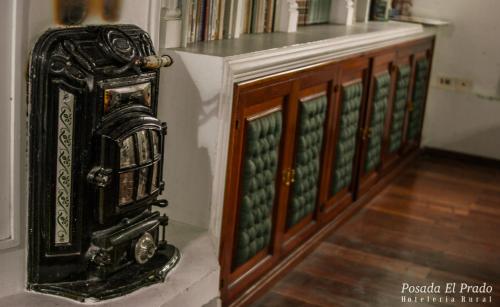 an old clock sitting next to a wooden cabinet at Posada El Prado in Salta