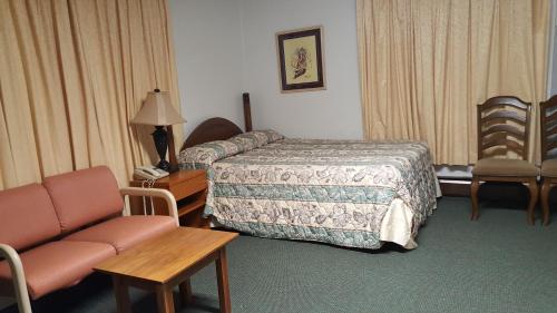 a hotel room with a bed and a couch at Borealis Inn in Fairbanks