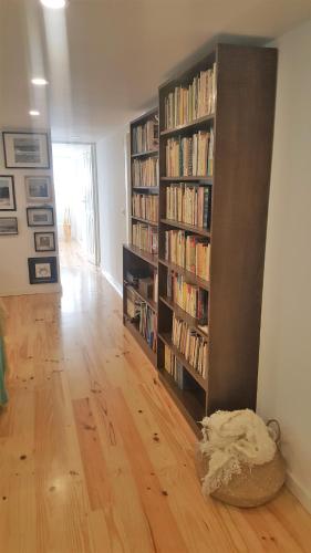 a living room with two book shelves filled with books at Carmo Apartment in Espinho