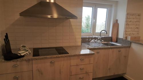 uma cozinha com um lavatório e um fogão forno superior em Carmo Apartment em Espinho