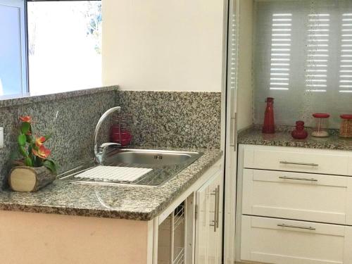 a kitchen counter with a sink and a window at Casa Nazare in Vilar Torpim