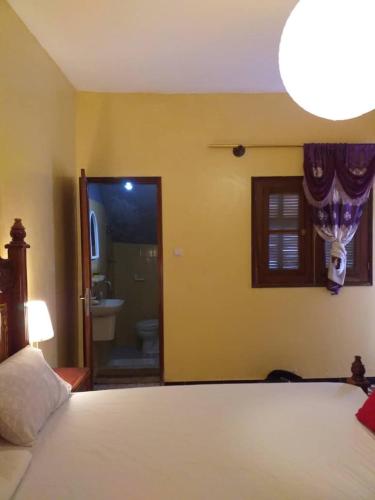 a bedroom with a bed and a bathroom at Maison d'Hôtes entière Cité Douane Golf Dakar in Dakar