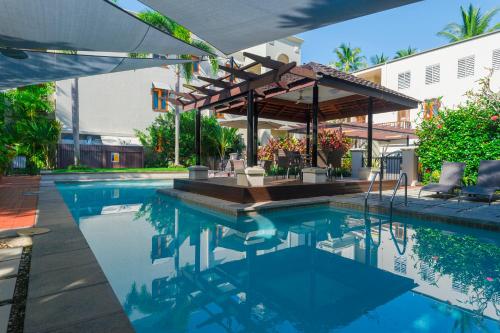 a swimming pool with a pavilion and a swimming poolvisor at LUXURY Apartment Studio PORT DOUGLAS 65 SQ MTRS and Bath in Port Douglas