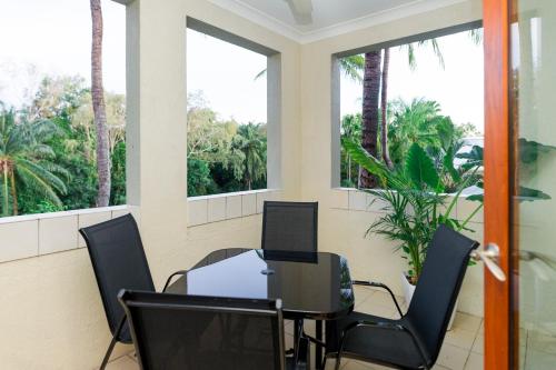 a room with chairs and a table and windows at LUXURY Apartment Studio PORT DOUGLAS 65 SQ MTRS and Bath in Port Douglas