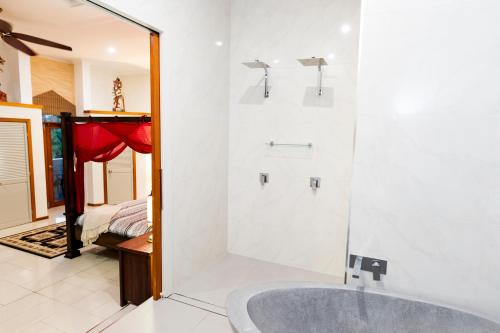 uma casa de banho com uma banheira e um chuveiro em vidro. em LUXURY Apartment Studio PORT DOUGLAS 65 SQ MTRS and Bath em Port Douglas