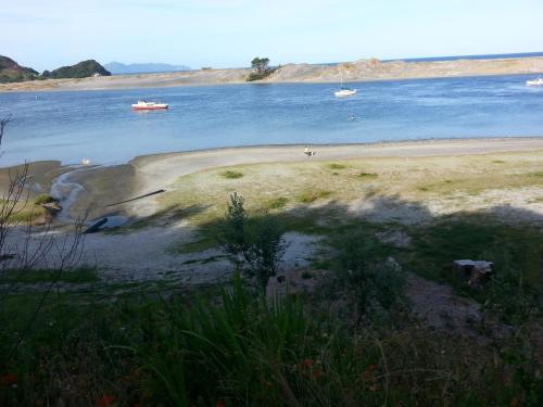 a beach with two boats in the water at Chalet Cullen, in Mangawhai