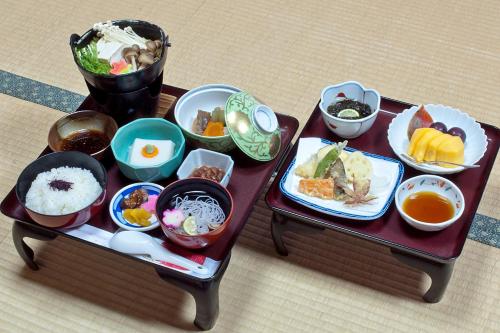 two tables with different dishes of food on them at Koyasan Shukubo Sainanin in Koyasan
