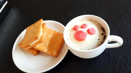 a cup of cappuccino and a plate of crackers and a cup at Dong Bi Villa in Gukeng