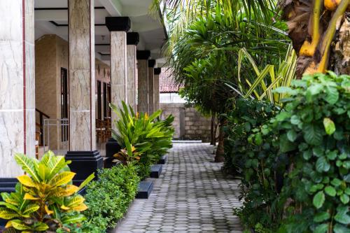 a walkway in a building with lots of plants at Megacahya Bungalow in Nusa Lembongan