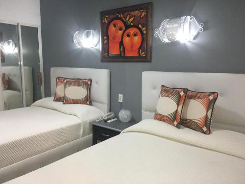 a bedroom with two beds and a painting on the wall at Hotel Rey in Concepción de La Vega