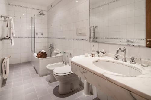 a white bathroom with a sink and a toilet at Grand Hotel Bastiani in Grosseto