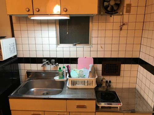 a kitchen counter with a sink and a sink at Casa Viento Stay Inn in Hiroshima