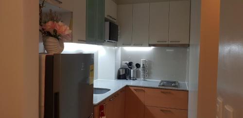 マクタンにあるOne Pacific Residence with Ocean Viewの冷蔵庫とシンク付きの小さなキッチン