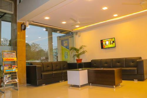 a living room with a couch and a table at Hotel Neem Tree in Shirdi