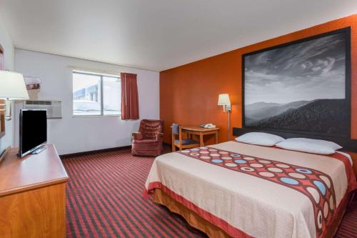 a hotel room with a large bed and a desk at Super 8 by Wyndham Dumfries/Quantico in Dumfries
