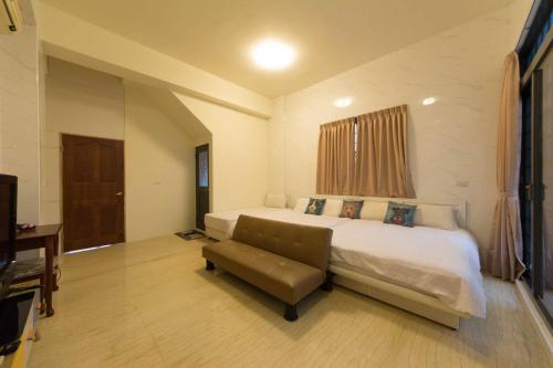 a bedroom with a large bed and a chair at 七號會館 in Puli
