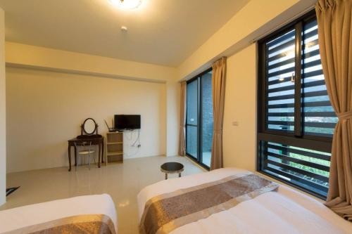 a bedroom with two beds and a large window at 七號會館 in Puli