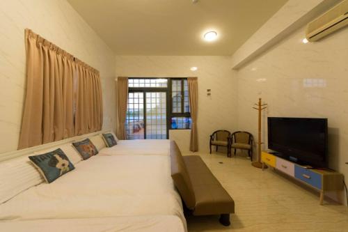 a bedroom with a large bed and a flat screen tv at 七號會館 in Puli
