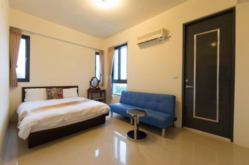 a bedroom with a bed and a blue chair at 七號會館 in Puli