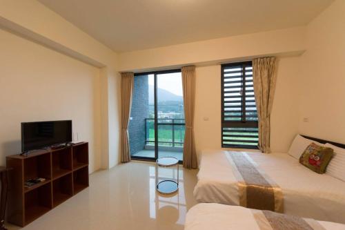 a hotel room with two beds and a large window at 七號會館 in Puli