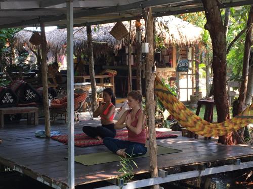 two women sitting on a deck doing yoga at Freedom home in Ko Chang
