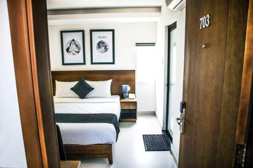 a small bedroom with a bed and a table at Robin Hotel Danang in Da Nang