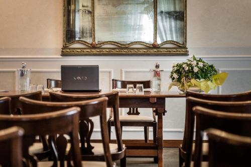 a dining room with a table with a laptop on it at Grand Hotel Bastiani in Grosseto