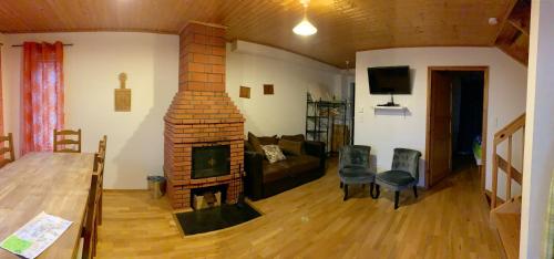 - un salon avec une cheminée en briques et un canapé dans l'établissement Les Chalets Fleurs de France - KOTA, à Saint-Dalmas