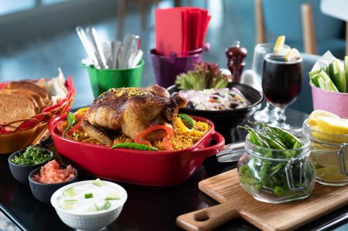 a table topped with a chicken and other food items at Park Inn by Radisson Jubail Industrial City in Al Jubail