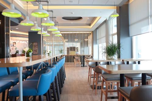 a dining room with tables and blue chairs at Park Inn by Radisson Jubail Industrial City in Al Jubail