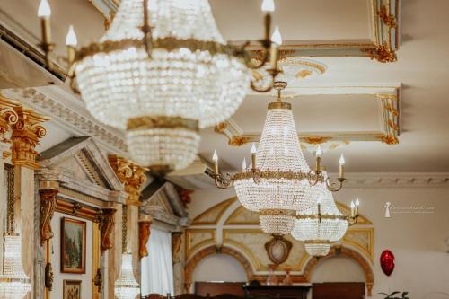 a room with chandeliers hanging from the ceilings at Hotel Książę Poniatowski in Lesznowola