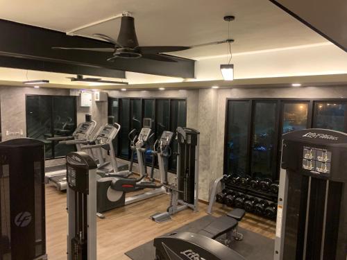 a gym with treadmills and machines in a room at Trio Residence Si-Racha in Si Racha