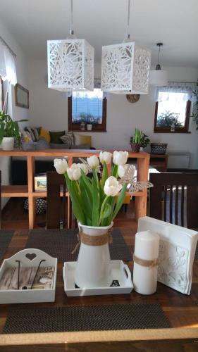 a table with a vase with white flowers on it at MJ Vila in Stará Lesná