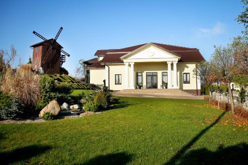 a house with a windmill in a yard at Pod Wiatrakiem in Warta