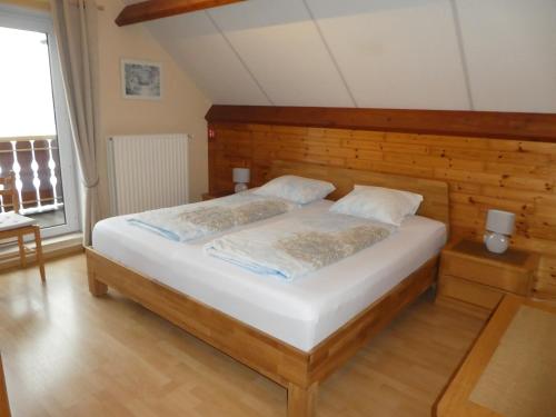 1 dormitorio con 1 cama grande y cabecero de madera en Huis Pimpernel, en Bredene