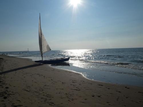 a sail boat on the beach with the sun shining at Huis Pimpernel in Bredene