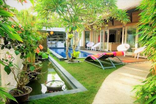 un cortile con piscina con amaca e una casa di Bamboo Moon Villas a Sanur
