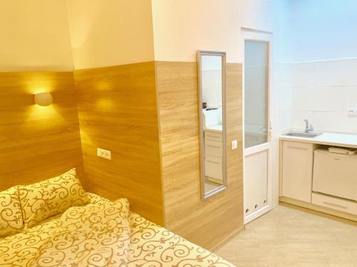 Habitación pequeña con cama y espejo. en Mini- Smart апартаменти в центральній частині Львова, en Leópolis