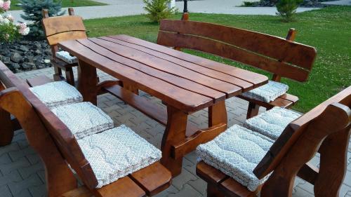 a wooden table and two chairs sitting next to a bench at MJ Vila in Stará Lesná