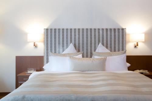 a bedroom with a large bed with white pillows at Minglers Sportalm - Das Gourmet- und Genießerhotel in Kirchberg in Tirol