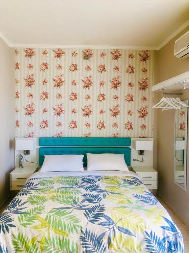 a bedroom with a bed with a blue headboard at Lovely Apartments D in Patra