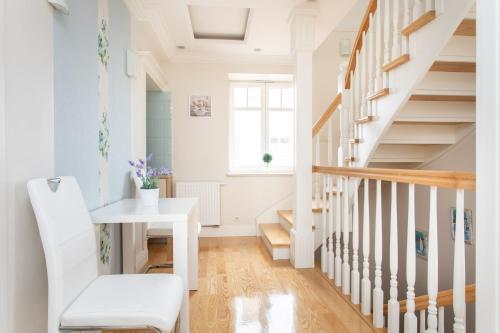 a white hallway with a white table and stairs at roomsy guest house in Sopot