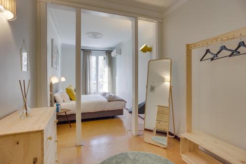 um quarto com uma cama e um espelho em Sweet Inn - Eixample Dreta em Barcelona